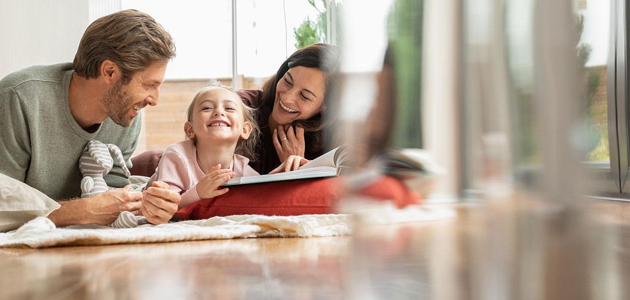 Buch lesendes Kind und lächelnde Frau